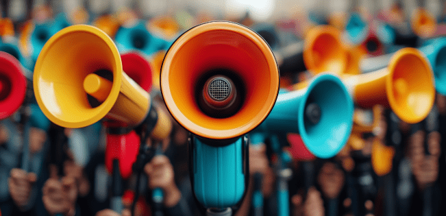 A vibrant red megaphone held high against a clear blue sky, symbolizing the power of voice and self-expression.